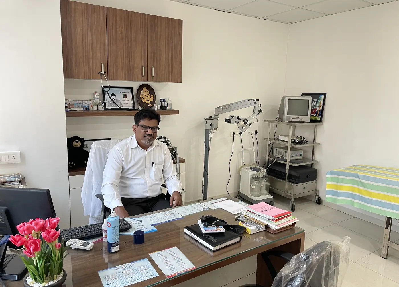 Dr. Sudhir Halikar, ENT specialist, in his consultation room at Hallmark Speciality ENT Clinic, Kharadi, with ENT examination equipment beside him