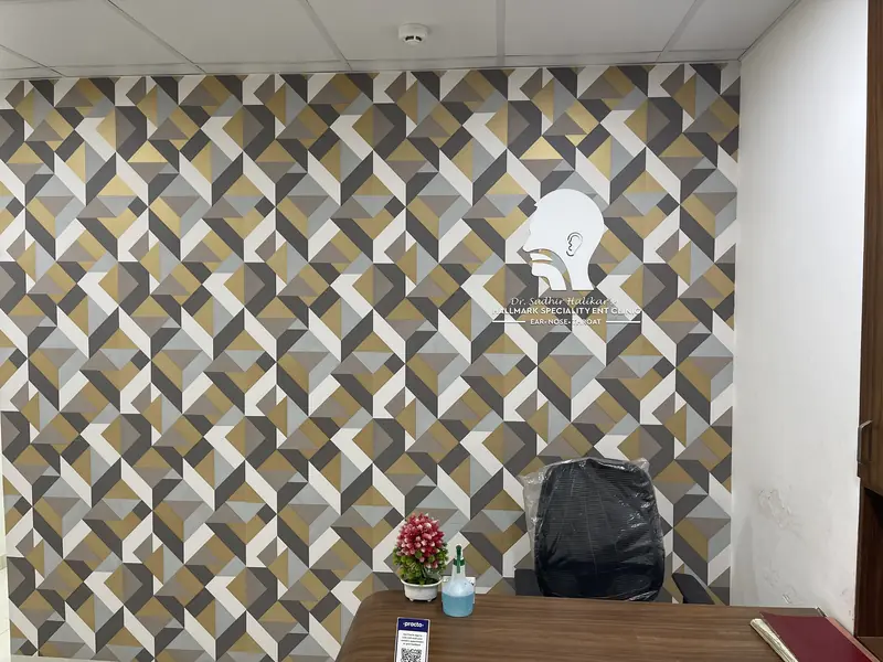 Reception desk at Hallmark Speciality ENT Clinic in front of a patterned feature wall with the clinic logo